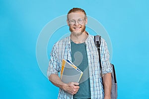 Portrait smiling college student in glasses standing hold copybooks backpack