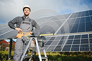 Portrait of smiling confident engineer technician with electrical screwdriver, standing in front of unfinished high