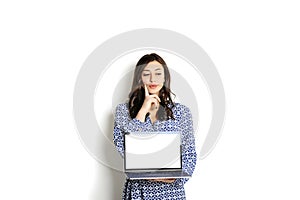 Portrait, smiling confident pretty woman long sleeve dress, holding grey laptop device and typing while standing against solid whi