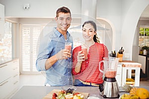 Portrait of smiling couple holding fruit juice