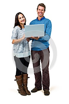 Portrait of smiling couple holding laptop