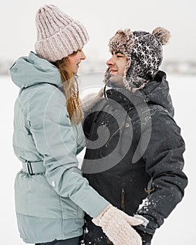 Portrait of smiling couple in love looking at each other. Young happy couple walking in winter