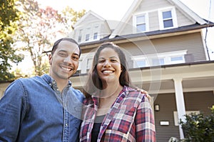 Portrait Of Smiling Couple Standing In Front Of Their Home