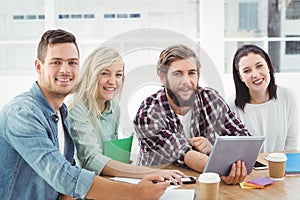 Portrait of smiling creative business people using digital tablet