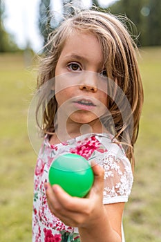 Portrait of smiling cute little girl playing with an old tennis racket