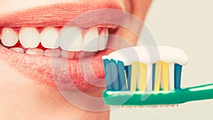 Portrait of a smiling cute woman holding toothbrush. Smiling woman with healthy beautiful teeth holding a toothbrush