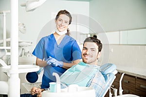 Portrait Of Smiling Dentist And Mid Adult Man In Clinic