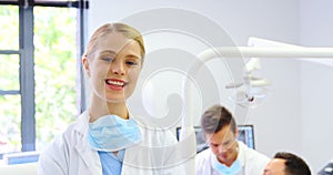 Portrait of smiling dentist standing with arms crossed