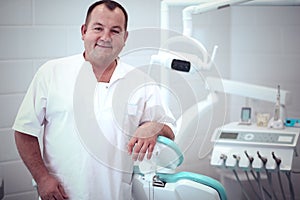 Portrait of a smiling dentist standing in dental clinic