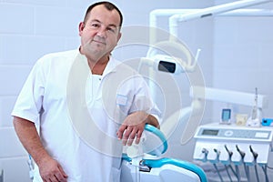 Portrait of a smiling dentist standing in dental clinic