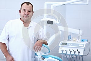 Portrait of a smiling dentist standing in dental clinic