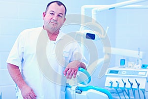 Portrait of a smiling dentist standing in dental clinic