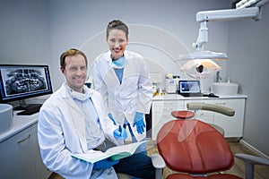 Portrait of smiling dentists holding medical report photo