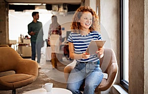 Portrait of a smiling designer, student, freelancer business woman using tablet computer