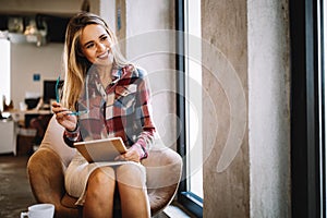 Portrait of a smiling designer, student, freelancer business woman using tablet computer