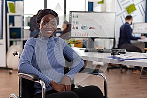 Portrait of smiling disabled paralyzed african american businesswoman in wheelchair