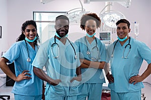 Portrait of smiling diverse surgeons wearing scrubs in operating theatre