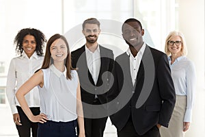 Portrait of smiling diverse work team standing posing in office