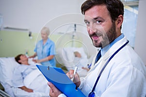 Portrait of smiling doctor checking a medical report