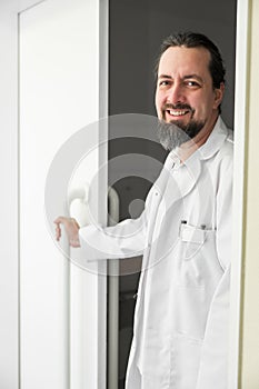 portrait of a smiling doctor standing at the door
