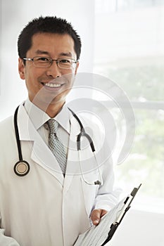 Portrait of smiling doctor with a stethoscope and medical chart