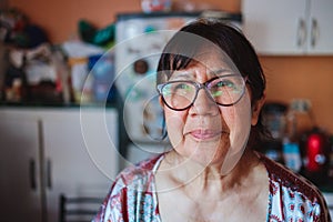 Portrait of a smiling elderly latin woman in her kitchen