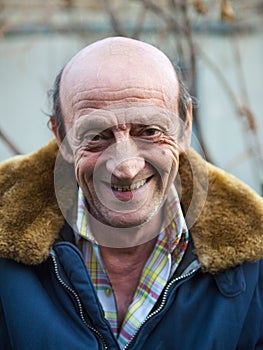 Portrait of a smiling elderly man outdoors closeup