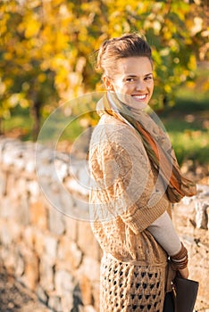 Portrait of smiling elegant brunette woman in autumn park