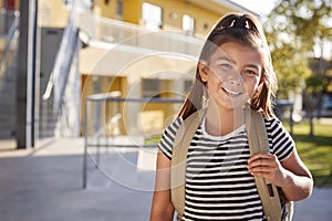 Portrait of smiling elementary school girl with her backpack