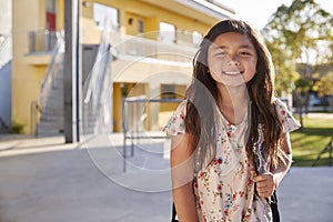 Portrait of smiling elementary school girl with her backpack