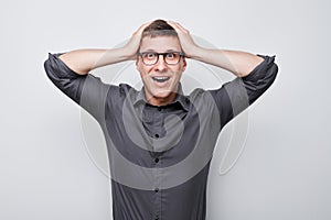 Portrait of smiling face man touching head and rejoicing, celebrating victory isolated on white studio background