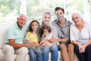 Portrait of smiling family with baby while sitting on sofa