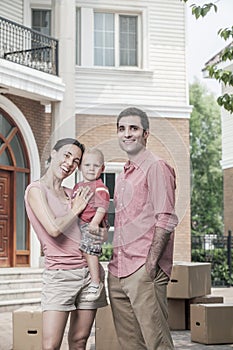 Portrait of smiling family in front of their new home