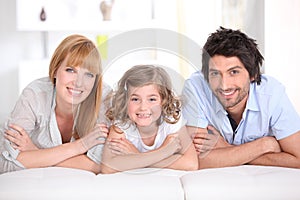 Portrait of a smiling family laid on a bed