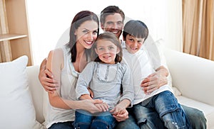 Portrait of a smiling family sitting on the sofa