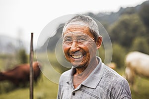 Portrait of smiling farmer with livestock in the background, rural China, Shanxi Province photo