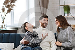 Portrait of smiling father, mother and son. Happy family spending time together at home. Cute boy with mom and dad