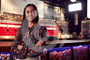 Portrait Of Smiling Female Bar Owner Standing By Counter