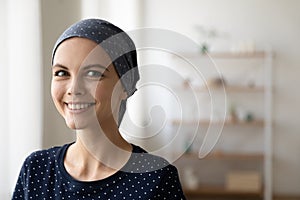 Portrait of smiling female cancer patient cover head