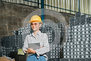 portrait of smiling female company employee holding a digital tablet in factory