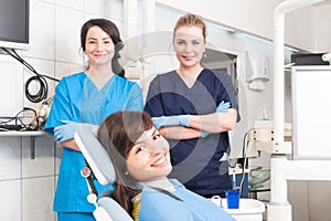 Portrait of smiling female dentist and assistant with female pat