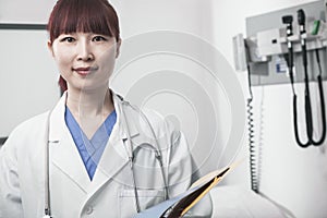 Portrait of smiling female doctor holding a clipboard