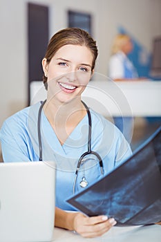 Portrait of smiling female doctor holding X-ray