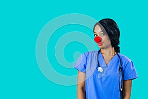 Portrait of a smiling female doctor or nurse wearing blue scrubs uniform