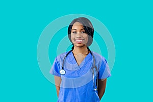 Portrait of a smiling female doctor or nurse wearing blue scrubs uniform