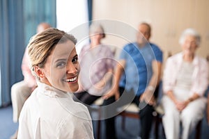 Portrait of smiling female doctor with senior people