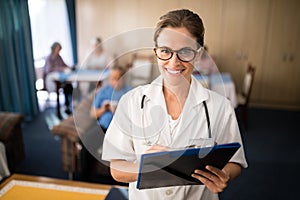 Portrait of smiling female doctor standing with file