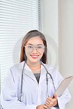 Portrait of smiling female doctor standing posing in her hospital office