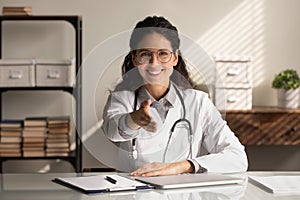 Portrait of smiling female doctor stretch had for handshake