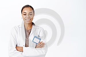 Portrait of smiling female doctor, therapist in white coat, looking confident with arms crossed. Medical healthcare
